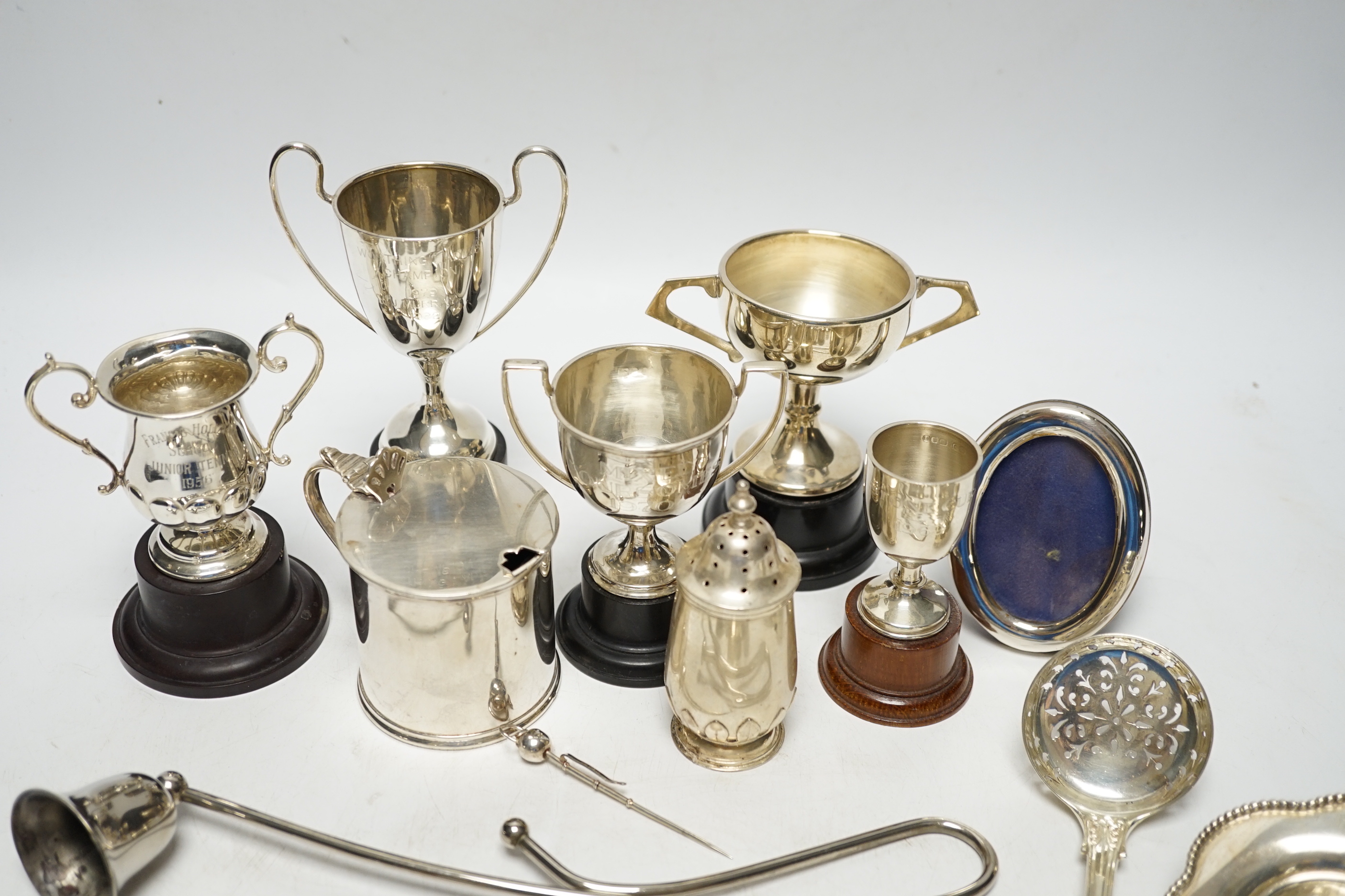Sundry minor silver flatware including a Victorian Kings pattern sifter ladle, a silver mustard pot and pepperette, four small silver trophy cups and two other items.